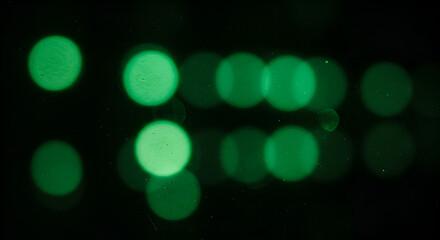 Green lights bokeh effect on a dark background perfect for technology aesthetics