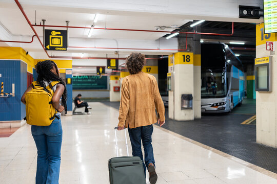 Tourists walking in bus station with luggage going to platform