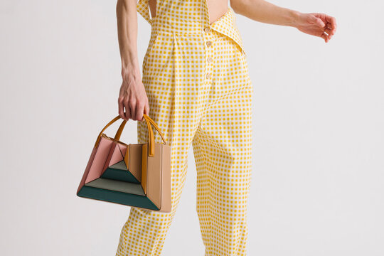 Colorful Geometric Handbag Held by Person in Yellow Gingham Pant