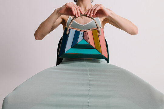 Colorful Designer Handbag Displayed by a Model in Stylish Settin