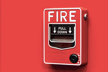 Fire alarm switch on red wall.