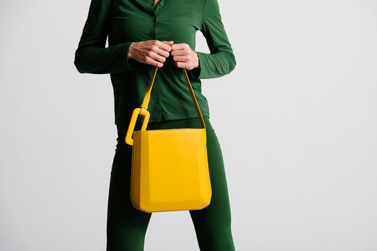 Close-Up of Stylish Yellow Handbag Held by Person in Green Attir