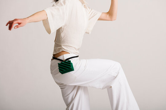 Person in White Outfit Holding Compact Green Accessory in Dynami