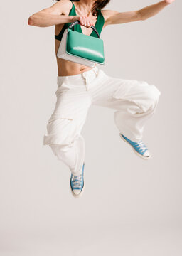 Fashionable Dynamic Pose Featuring Vibrant Green Bag and Blue Sn