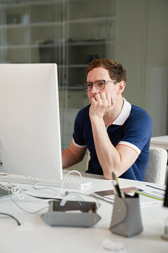 Focused Young Professional Working on a Computer in a Modern Office