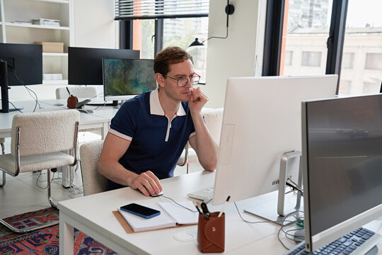Focused Young Professional Working on a Computer in a Modern Office