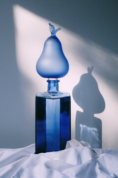 Blue decorative pear shaped object on a glass bottle