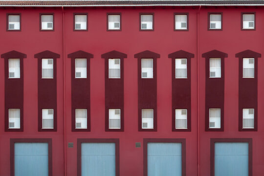 Symmetrical Red Building Facade with Windows and Doors