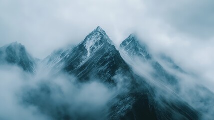 67.Dense morning fog covering a mountain peak, soft clouds rolling over jagged ridges, mystical and surreal, hidden landscape