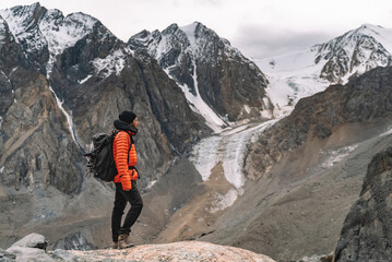 Solo hiker gazing at glacier mountainscape