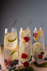 refreshing sparkling water served in tall glasses with citrus slices and berries, capturing a clean...