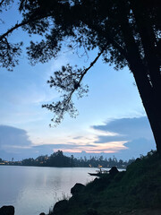 Scenic Lake View at Sunset with Silhouette Trees and Boat