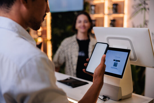 Customer paying with phone at point of sale.