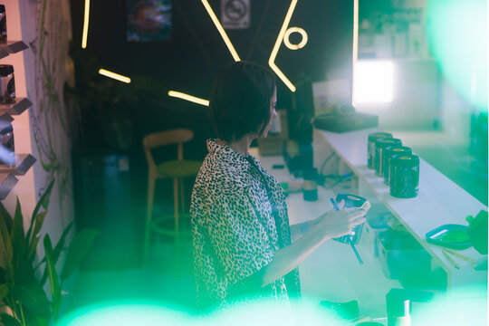 Woman at dispensary counter, possibly taking inventory.
