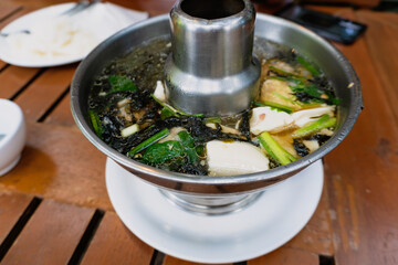 Clear Soup with Tofu and Seaweed in a hot pot on the table