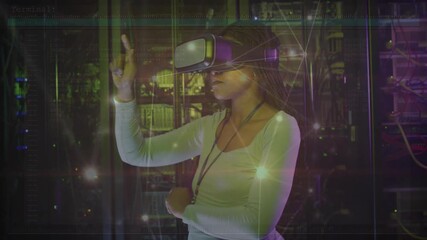 Engineer wearing VR headset in server room extending finger tapping pulsing network nodes testing - Powered by Adobe