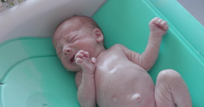New Born Baby Rinsing Off In Bath.