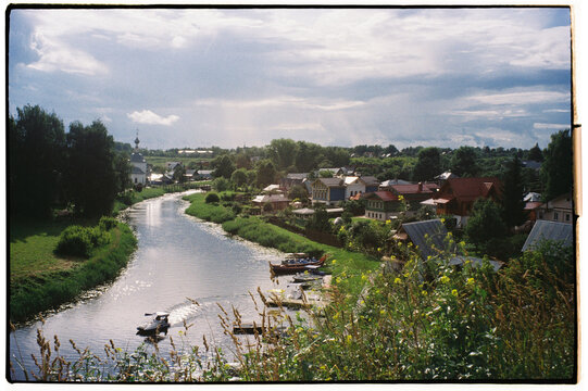 Serene river view with boats and lush greenery in a quaint town