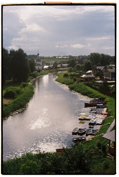 Serene river view with boats and lush greenery in a quaint town