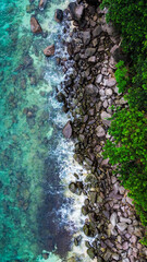 Scenic aerial perspective of ocean waves breaking on a rocky coastline.