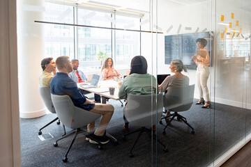Businesswoman leading presentation to coworkers in modern office