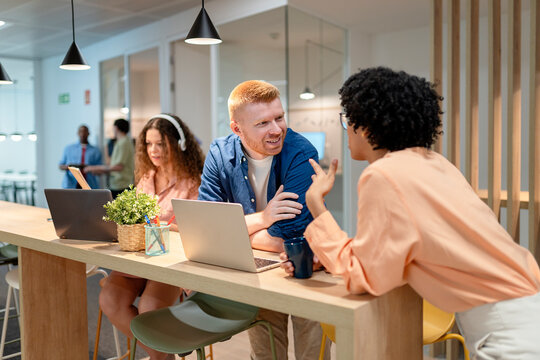 Business people collaborating in modern office using laptops