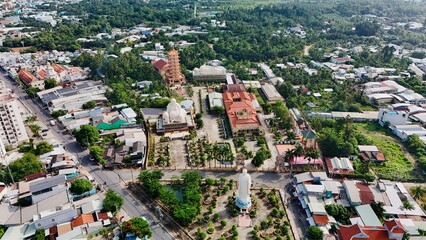 Fototapeta premium Vinh Trang Pagoda, My Tho, Mekong Delta, Vietnam: 4K Aerial View of Buddhist Temple with Giant Standing, Sitting, and Reclining Buddha Statues Surrounded by Gardens and Traditional Architecture