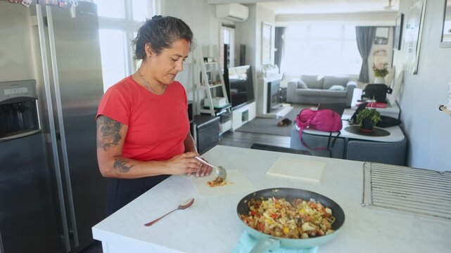 Woman preparing spring rolls in a kitchen