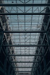 Obraz premium Steel construction framework of modern industrial building under development, structural metal beams and architecture engineering background for construction, infrastructure, and industry