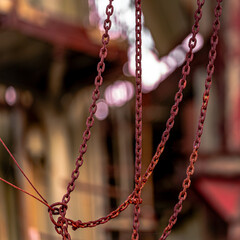 Rust red, dirt and cobwebs. Chains in a macro photo.