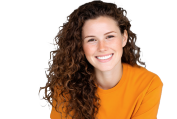 A young woman with curly brown hair and freckles smiles, wearing an orange shirt, exuding a friendly and positive vibe.
