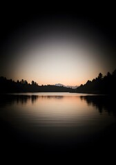 Fototapeta premium Tranquil lake at dusk reflects the silhouette of trees and distant mountains under a soft sky.