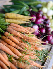 A table filled with fresh vegetables on display, like carrots onions and beetroots