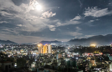 Glowing full Moon Rising Over a City at Night