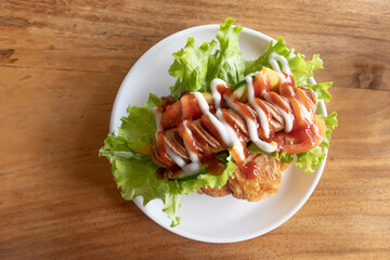 Delicious Croissant filled with Sausage lettuce tomato top with chili sauce and mayonnaise