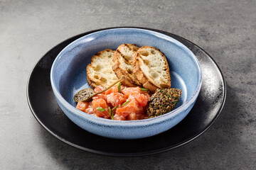 Salmon tartare with ciabatta and olive tapenade in rustic bright overhead composition