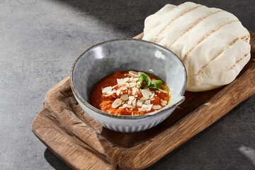Muhammara roasted pepper spread with pita bread, bright lighting, overhead composition