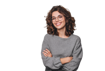 A young woman with curly hair and glasses smiles, wearing a gray sweater in a casual style.