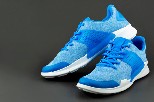 Shop display of unbranded modern new stylish sneakers running shoes for men isolated on black background.