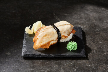 Sushi with eel on rice, rustic lighting, overhead composition, slate plate presentation
