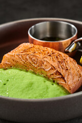 Grilled salmon steak with wasabi puree, moody lighting, closeup composition