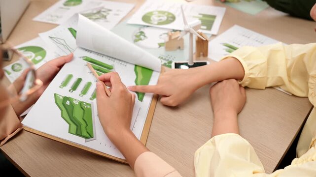 Business team analyze green power graph usage. Coworker with windmill model represented using clean energy and wooden block symbolized eco house choosing way to decrease carbon in future. Delineation.