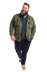 Fototapeta premium A bearded man wearing a green jacket and blue pants walks outdoors in casual attire.