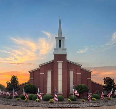 Mormon church at beautiful sunset. In front of the church American flags displayed in honor of Independence Day.