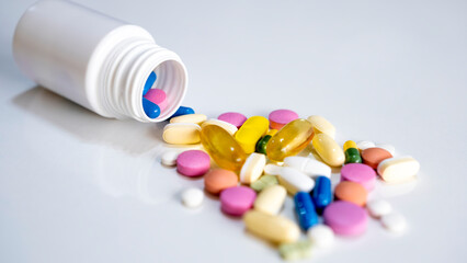 Close-up and top shot Pills, tablets, capsules, vitamins and omega3 on the white table with drug box