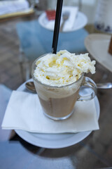 Glass of iced coffee with whipped cream topping
