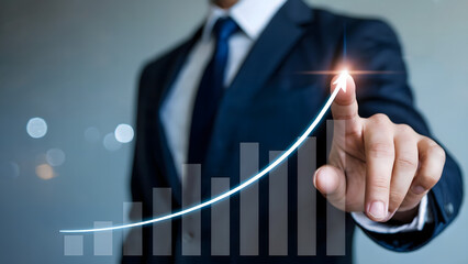 A professional business image showing a man in a suit and tie touching a glowing upward arrow on a digital growth graph.