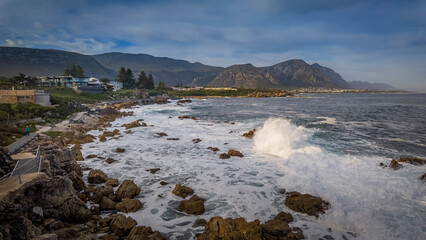 Panoramic views of the scenic Cliff Path winding along the Hermanus coastline, overlooking Walker Bay, rugged rocks, and mountains in the Whale Coast, Overberg, Western Cape, South Africa.