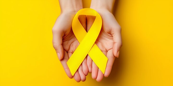 Yellow Ribbon Awareness Symbol Held in Hands for Health and Support Causes