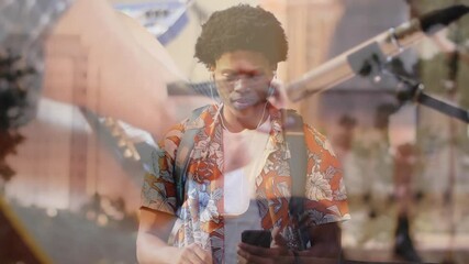 Male student tapping phone screen launching music app overlaying guitar strings spotting performer - Powered by Adobe